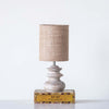 Small whitewashed lamp with jute shade on a book on white surface