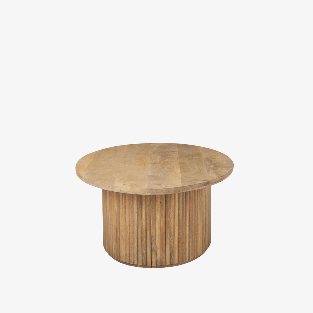 Light wood oval coffee table with reeded wood base on a white background