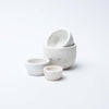Set of four White marble nesting bowls for measuring on a white background