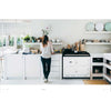Photograph of woman in white kitchen from book 'This is Home:The Art of Simple Living' 