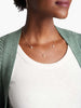 Able brand triple pearl gold necklace on a model with white teeshirt and green sweater