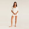 Model wearing Z Supply White V-Neck Terry Short in front of a creme background