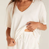 Model wearing Z Supply White V-Neck Terry Short in front of a creme background
