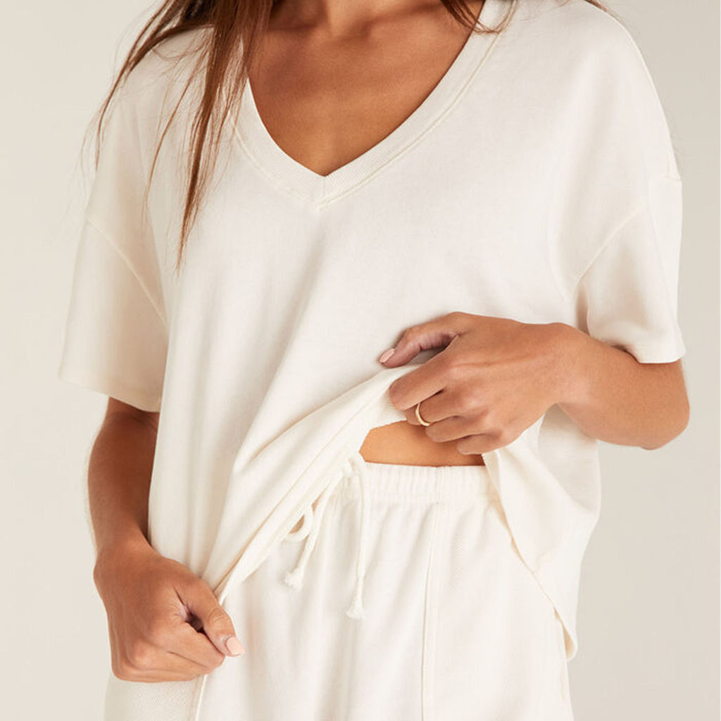 Model wearing Z Supply White V-Neck Terry Short in front of a creme background
