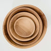 Four beech salad bowls nested together on a white background