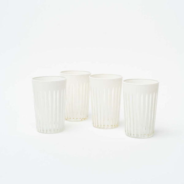 Set of four hand carved white tea glasses on a white background