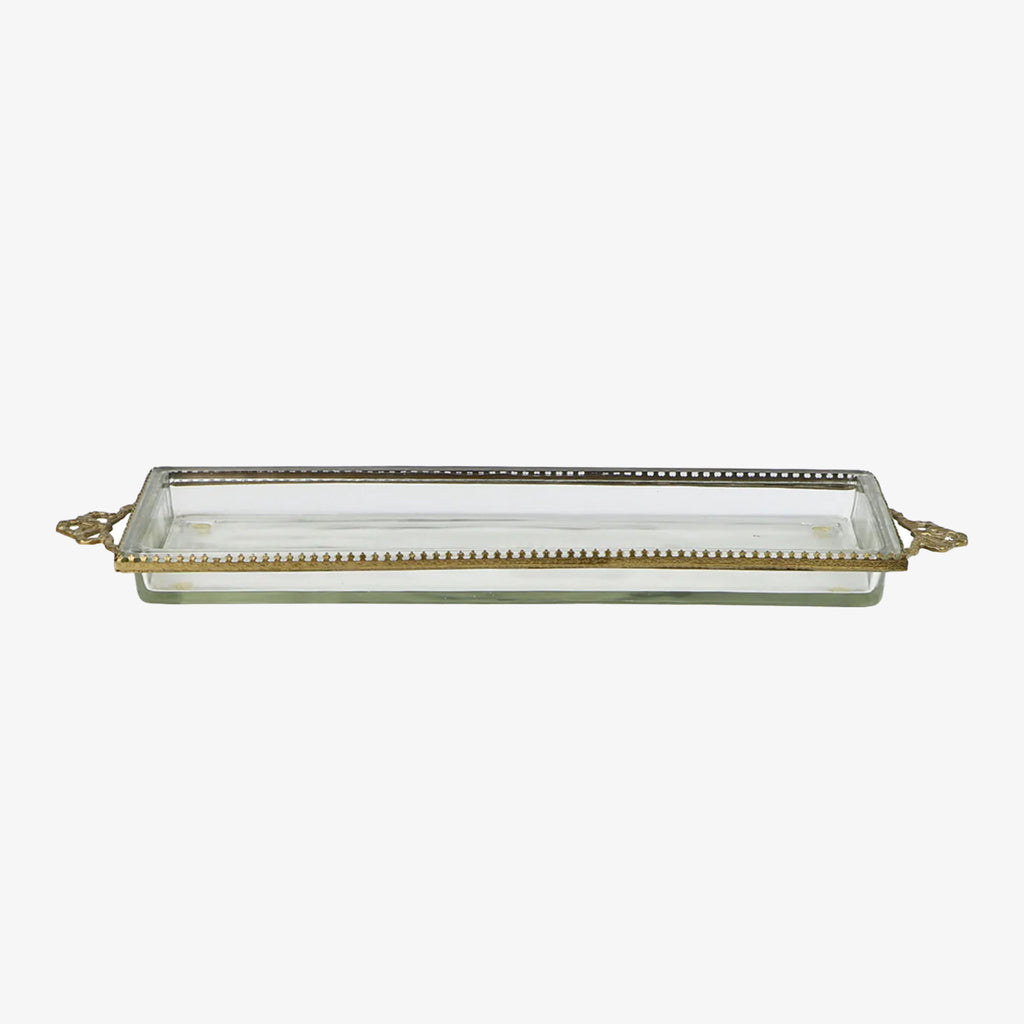 Glass tray with metal brass scallop edging and decorative metal bows on ends on a white background