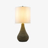 Gray glazed ceramic table lamp with white linen shade on a white background