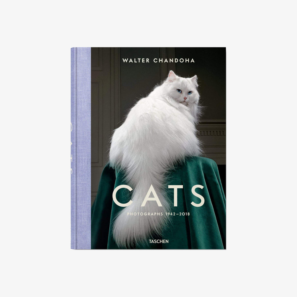 Cover of book titled Cats by Walter Chandoha with large white furry cat sitting green drapery