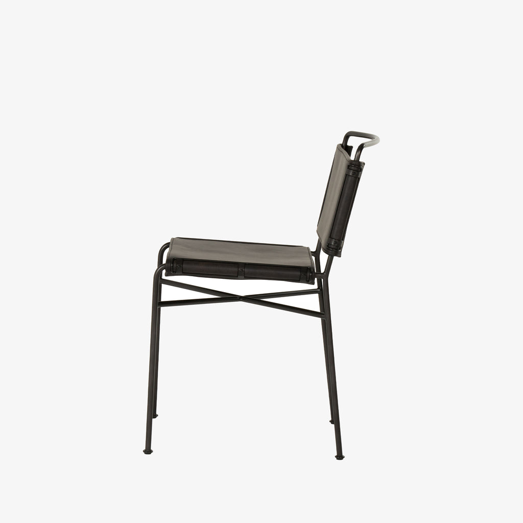Side view of Four hands brand wharton chair with black iron frame and black leather seat on a white background