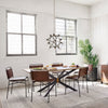 Dining room table in industrial white loft space with Four hands brand wharton chair with black iron frame and dark brown leather seats around table