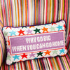 Embroidered pillow with stars and saying 'why go big when you can go home' on a stripe chair