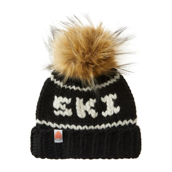Shit that I knit brand kids beanie with embroidered Ski in navy with faux fur pompom on a white background